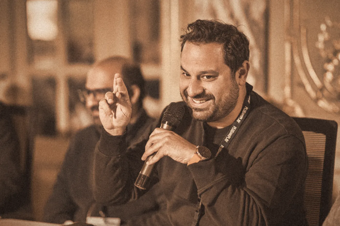 Ahmad laughing mid-answer with a microphone