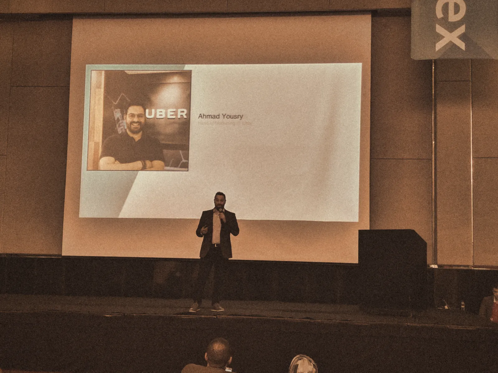 Ahmad keynoting with the Uber title slide on screen